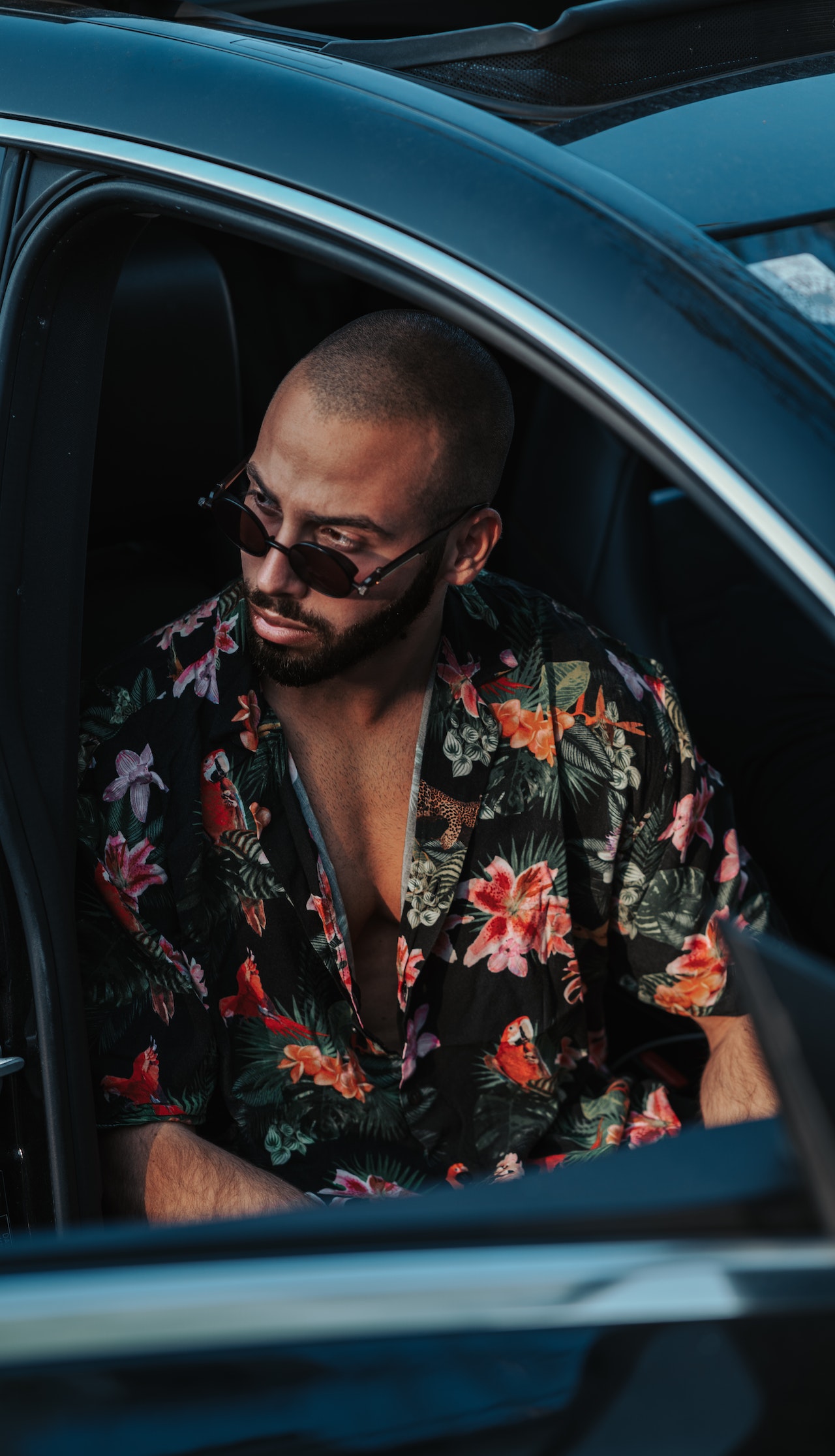 Wealthy man sitting in and enjoying his new car.